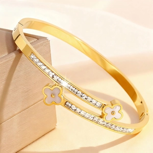 Detail of gold clover bangle with double rows of square diamonds on a jewelry box