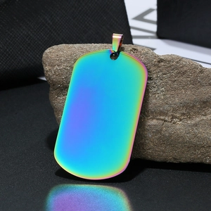 Macro-opname van een gepolijste regenboog dog tag hanger op een ruwe grijze steen