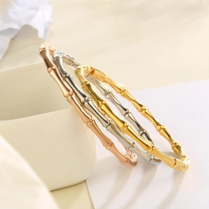 Macro detail of polished stainless steel bamboo joint bracelets in gold and silver finish