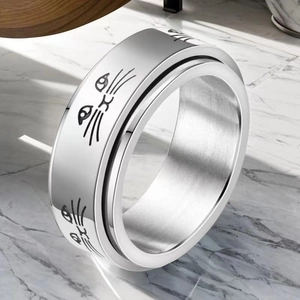Gros plan sur la bague rotative en acier inoxydable avec motif chat gravé sur marbre
