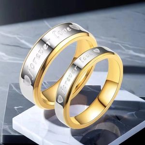 Macro view of gold and silver couple rings with forever love engraving and heart details