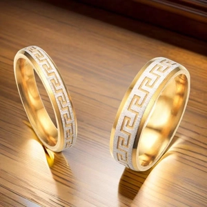 Détails de bagues de couple en acier titane doré avec motifs de clé grecque sur bois