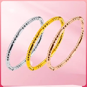 Polished steel bangles in silver, gold, and rose gold with industrial beaded design