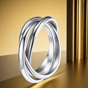 Macro shot of silver trinity rolling rings with high polish finish on golden pedestal