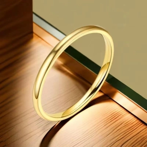 Close-up of a polished 18K gold-plated titanium steel minimalist ring on a wooden surface