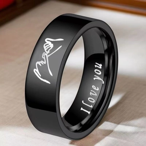 Macro shot of black titanium steel ring with I love you engraving and artistic signature