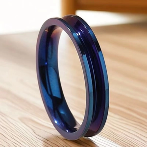 Détail d'une bague en acier titane avec dégradé bleu-violet et rainure centrale sur bois