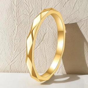 Detail showing a golden geometric faceted ring with minimalist polyhedron structure