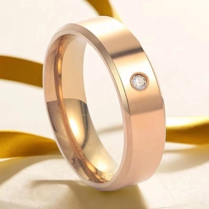 Detailed view of rose gold titanium ring with a flush-set round sparkling gemstone
