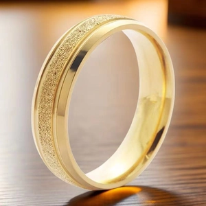 Dettaglio anello in acciaio dorato con centro satinato ed eleganti bordi lucidi