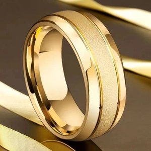 Détail d'une bague en acier doré avec finition mate sablée et bords polis miroir