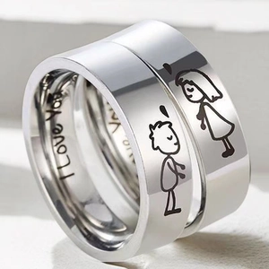 Macro detail of polished titanium steel rings featuring cartoon figures and I Love You engraving