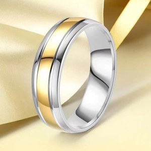 Macro shot of two-tone gold and silver stainless steel ring on satin fabric