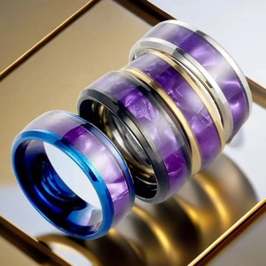 Macro detail of titanium rings with purple marble inlay in blue, gold, black and silver finishes
