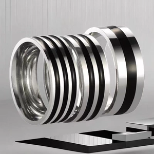 Modern titanium steel rings with black inlay displayed in a creative floating arrangement