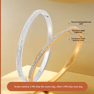 Detail of 18k gold plated titanium steel bangles with sparkling zircon stone inlay