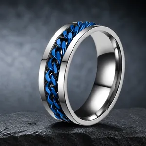Edelstahl-Spinnerring für Herren mit blauer Kette vor Wasserspritzer-Hintergrund
