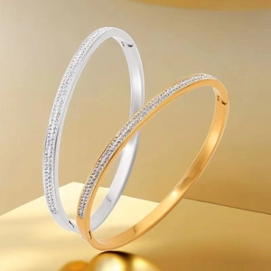 Close-up of gold and silver plated bangles with pave-set zircon crystals on golden pedestals