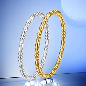 Close-up of bamboo style gold and silver stainless steel bangles with bead detailing