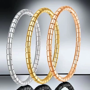 Close-up of titanium steel bangles in silver, gold, and rose gold with ribbed texture