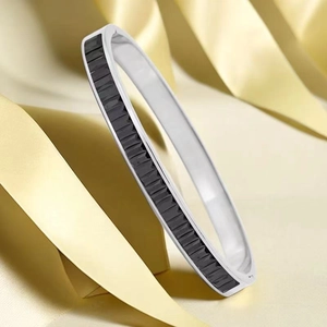 Gros plan détaillé d'un bracelet jonc en acier inoxydable argenté à incrustations noires