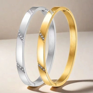Gros plan de bracelets en acier titane or et argent avec diamants et texture brossée
