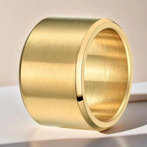 Macro view of wide gold brushed stainless steel ring with a matte industrial texture