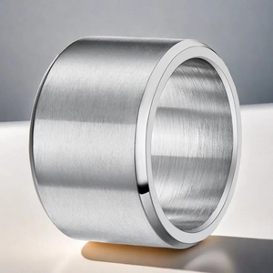 Macro shot of silver brushed stainless steel wide band ring with industrial matte texture
