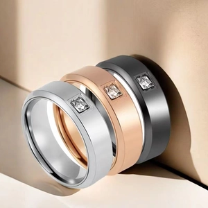Detailed view of three stackable stainless steel rings with square zirconia in gold and black