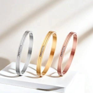 Detailed view of polished stainless steel bangles with double grooves and set zircons