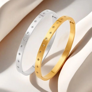 Close-up of gold and silver stainless steel bangles with sparkling starburst engraving