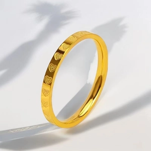 Macro detail of 18k gold plated ring with continuous heart embossing and polished finish