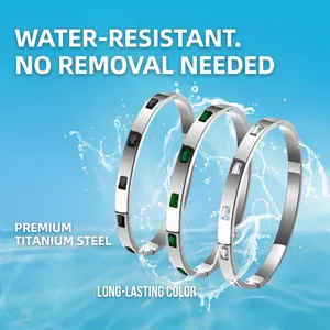 Set di tre braccialetti in acciaio al titanio con zirconi colorati su sfondo d'acqua