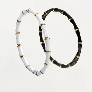Bamboo style titanium steel bracelets in black and white enamel with gold accents