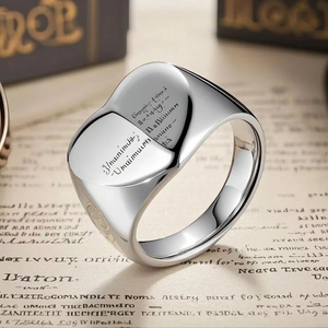 Vintage silver heart signet ring with engraved artistic symbols on a retro paper background