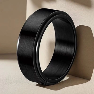 Dettaglio di un anello rotante nero opaco con finitura spazzolata su base geometrica