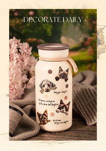 Detail of insulated cream travel mug with pet illustrations on a cozy wooden desk