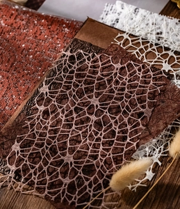 Detail of vintage hollow mesh decorative paper in white, brown and brick red tones