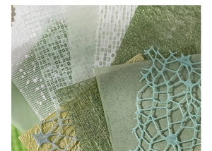 Macro shot of layered mesh and textured scrapbooking paper in fresh green and blue tones