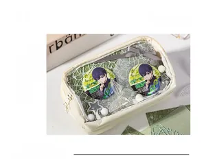 Close-up of cream ita bag with transparent window showing Blue Lock anime badges and lace