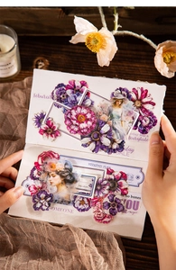 Detailed view of vintage floral and portrait PET stickers applied to a notebook page