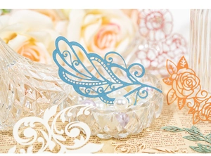 Detail view of laser-cut paper scrapbooking kit with lace flower and feather patterns
