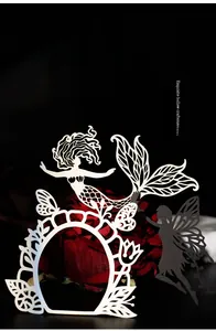 Macro detail of laser-cut paper silhouettes featuring mermaid and fairy wing patterns