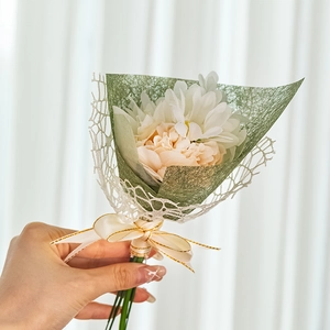 Mini floral bouquet with white daisy and pink carnation in green mesh lace wrapping