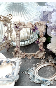 Detailed close-up of vintage white decorative frames with purple butterfly relief art