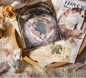Detailweergave van Dark Charm Rose stickers met gotische vleugels op vintage houten bord