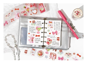 Detail view of cute pink PET stickers with bows and rabbits on a silver binder