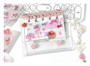 Detail of pink binder notebook with cute strawberry and bow stickers for DIY journaling