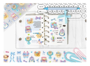 Cute Pomeranian and dessert stickers arranged on a loose-leaf journal with stationery items