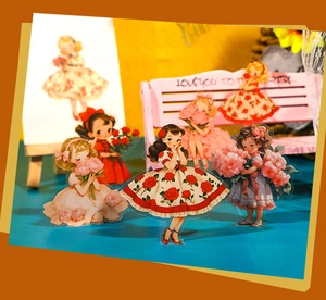 Close-up of vintage fairy garden girl stickers with floral dresses for scrapbooking DIY